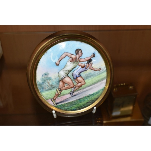 404 - AN EARLY 20TH CENTURY SPORTING  ENAMEL PLAQUE DEPICTING TWO MALE ATHLETES IN A SPRINT, brass coated ... 