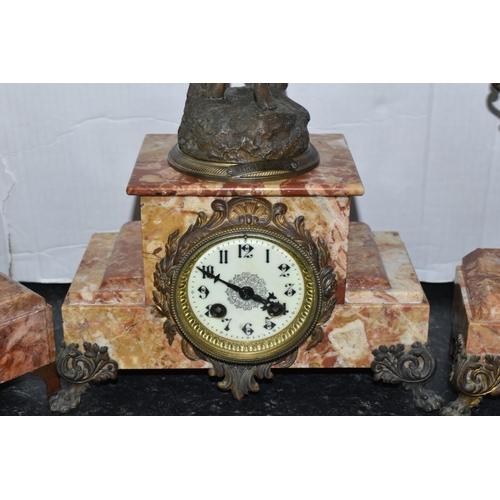 473 - A FRENCH ROSE MARBLE CLOCK GARNITURE, clock supporting a bronzed figure of a woman 'Rayon De Soleil'... 