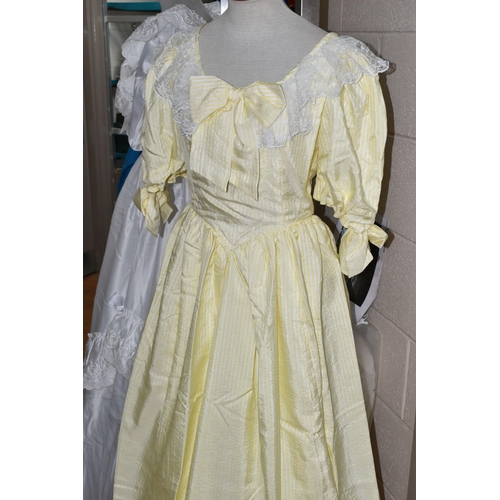 482 - A 1980S PRONUPTIA WHITE SATIN WEDDING DRESS AND LEMON AND WHITE STRIPED BRIDESMAID DRESS, comprising... 