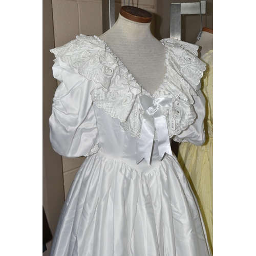 482 - A 1980S PRONUPTIA WHITE SATIN WEDDING DRESS AND LEMON AND WHITE STRIPED BRIDESMAID DRESS, comprising... 