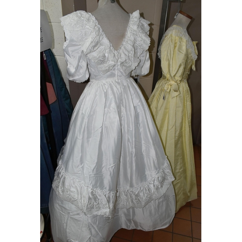 482 - A 1980S PRONUPTIA WHITE SATIN WEDDING DRESS AND LEMON AND WHITE STRIPED BRIDESMAID DRESS, comprising... 