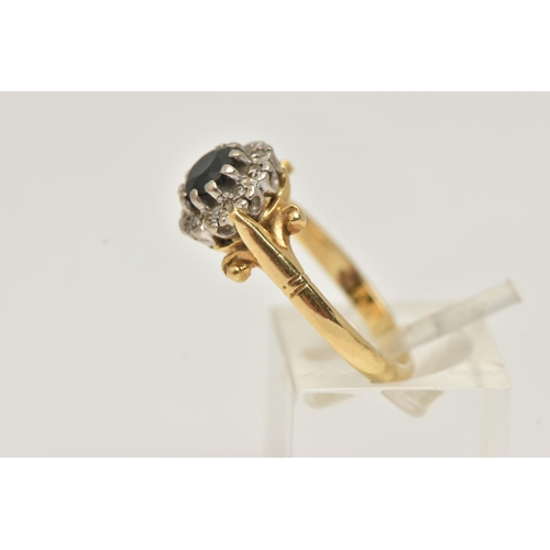 27 - AN 18CT GOLD SAPPHIRE AND DIAMOND CLUSTER RING, set with a circular cut sapphire, bordered by ten si... 