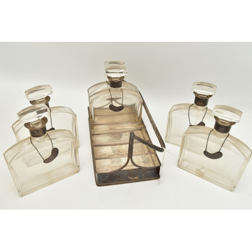 163 - A GEORGE V SILVER AND GLASS DECANTER SET, six glass decanters (one has a large fracture down the cen... 