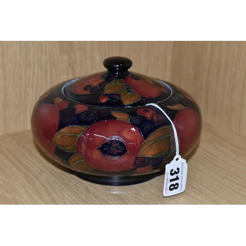 318 - A MOORCROFT POTTERY 'POMEGRANATE' PATTERN COVERED JAR, comprising a deep purple and red pomegranate ... 