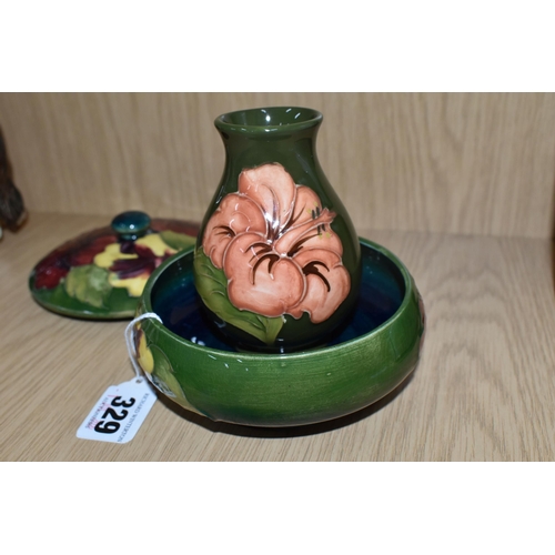 329 - TWO PIECES OF MOORCROFT POTTERY, comprising a small 'Hibiscus' pattern bud vase, a coral coloured hi... 