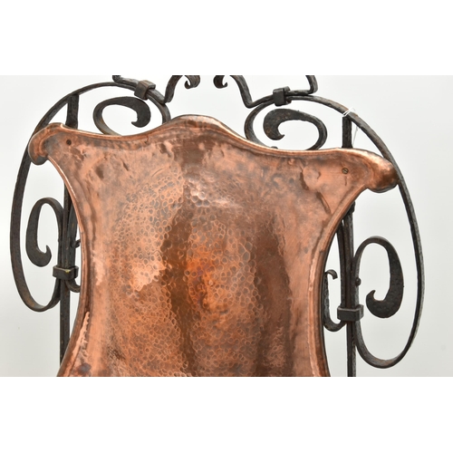 60A - AN ARTS AND CRAFTS STYLE PLANISHED COPPER AND WROUGHT IRON FIRE GUARD, the wrought iron scrolling fr... 