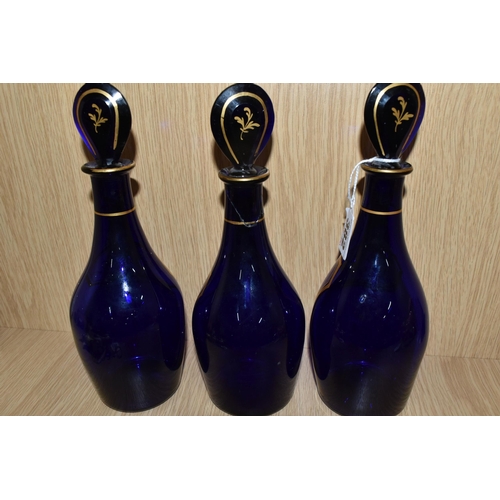 382 - A SET OF THREE BRISTOL BLUE GLASS DECANTERS, gilt label design on each bottle and stopper 'Rum', 'Br... 