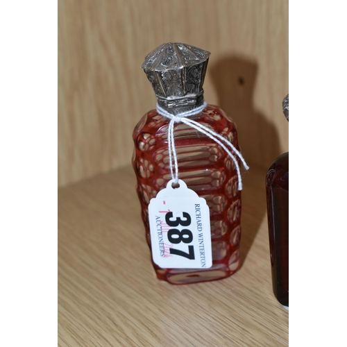 387 - THREE VICTORIAN CRANBERRY GLASS SCENT BOTTLES, comprising two cut cranberry glass bottles with flora... 