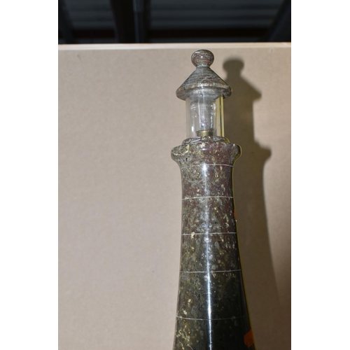 421 - A TURNED CORNISH SERPENTINE LAMP in the form of a lighthouse with a transparent glass shade on a roc... 