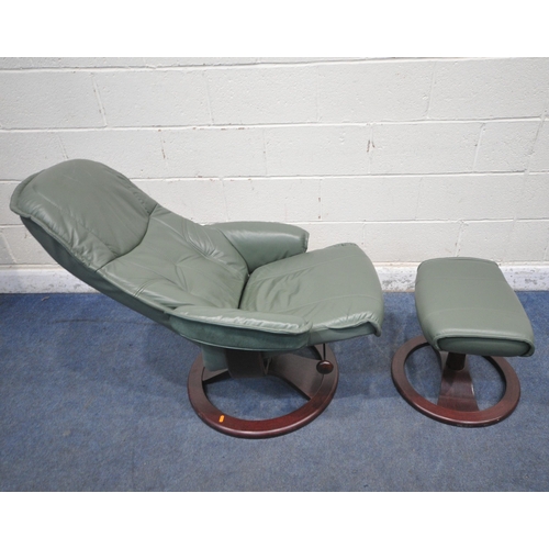 1206 - A GREEN LEATHER SWIVEL RECLINING ARMCHAIR, along with a footstool (condition report: general signs o... 