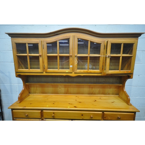 1233 - A LARGE MODERN PINE DRESSER, the top fitted with four glass doors, atop a base with three drawers ab... 