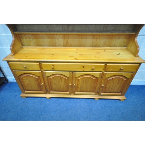 1233 - A LARGE MODERN PINE DRESSER, the top fitted with four glass doors, atop a base with three drawers ab... 