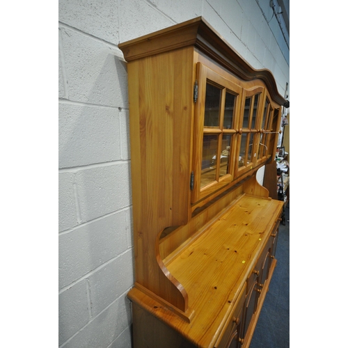 1233 - A LARGE MODERN PINE DRESSER, the top fitted with four glass doors, atop a base with three drawers ab... 