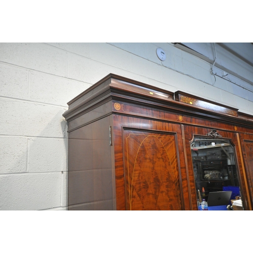 1238 - AN EDWARDIAN MAHOHANY COMPACTUM WARDROBE, the double doors flanking a central bevelled mirrored door... 