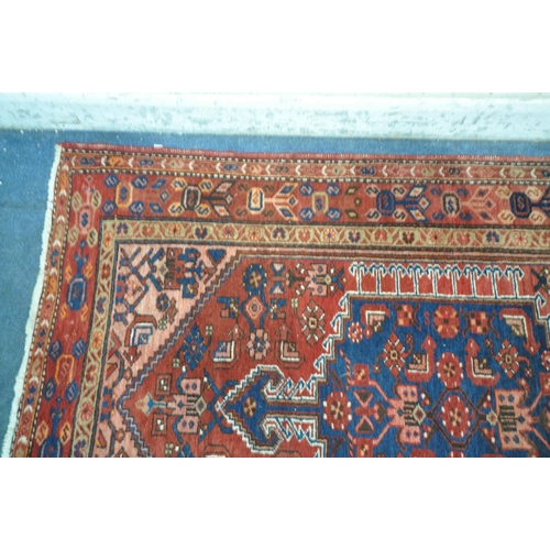 1262 - A PERSIAN RED RUG, with a repeating pattern, and multi strap, 202cm x 130cm (condition report: sun b... 