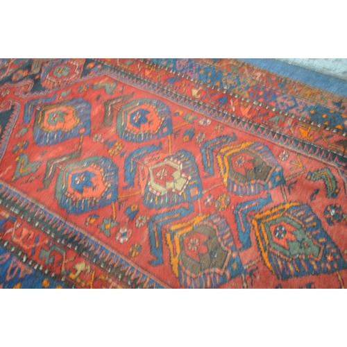 1264 - A PERSIAN RED RUG, the centre with seven shaped patterns, repeating design that's surrounds, and a m... 