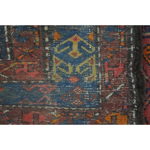 1264 - A PERSIAN RED RUG, the centre with seven shaped patterns, repeating design that's surrounds, and a m... 