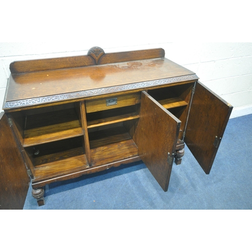 1268 - AN EARLY 20TH CENTURY OAK SIDEBOARD, fitted with three cupboard doors, the central and right hand do... 