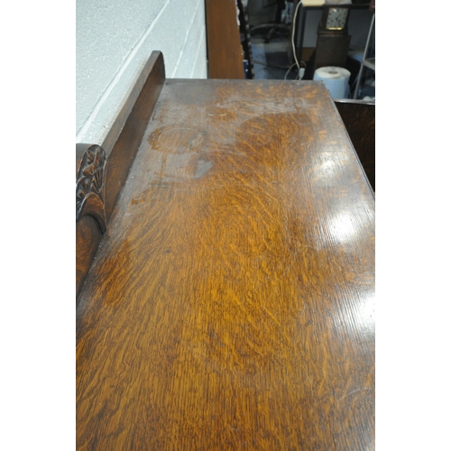 1268 - AN EARLY 20TH CENTURY OAK SIDEBOARD, fitted with three cupboard doors, the central and right hand do... 