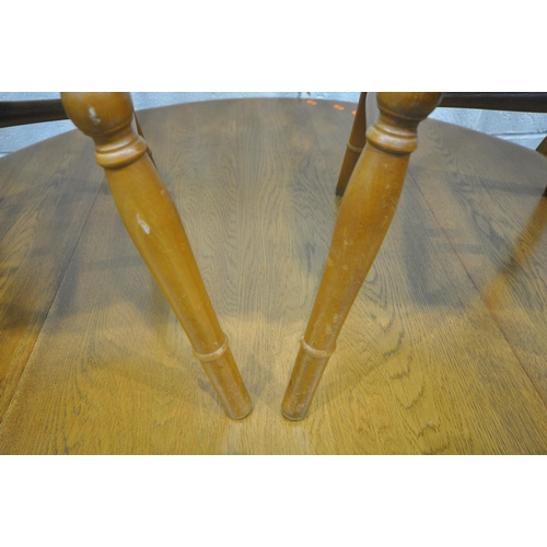 1314 - A LATE 20TH CENTURY OAK DROP LEAF DINING TABLE, raised on trestle legs, diameter 121cm x closed widt... 