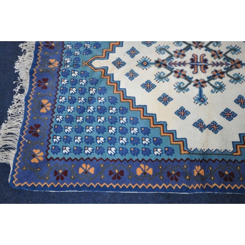 1344 - A BLUE AND CREAM TUNISIAN RECTANGULAR WOOLEN RUG, with repeating patterns, 203cm x 146cm (condition ... 