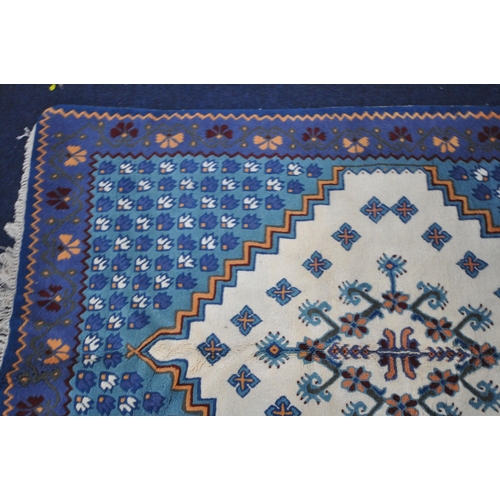 1344 - A BLUE AND CREAM TUNISIAN RECTANGULAR WOOLEN RUG, with repeating patterns, 203cm x 146cm (condition ... 