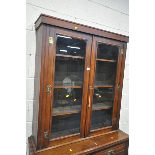 1253 - AN EARLY 20TH CENTURY MAHOGANY BOOKCASE, the double glazed doors enclosing three shelves, atop a bas... 