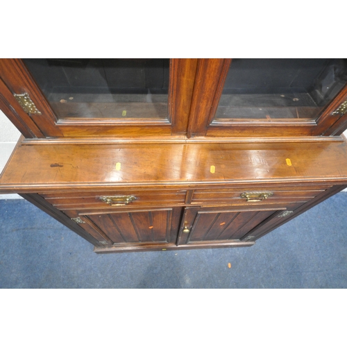 1253 - AN EARLY 20TH CENTURY MAHOGANY BOOKCASE, the double glazed doors enclosing three shelves, atop a bas... 