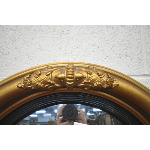 1257 - A REGENCY STYLE CICRULAR CONVEX WALL MIRROR, the frame with carved details (condition report: some s... 