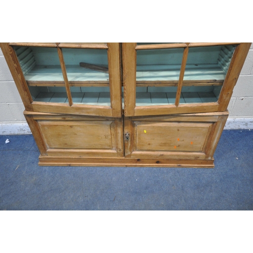 1261 - A 19TH CENTURY PINE BOOKCASE,  the two glazed doors enclosing an arrangement of shelving, above two ... 