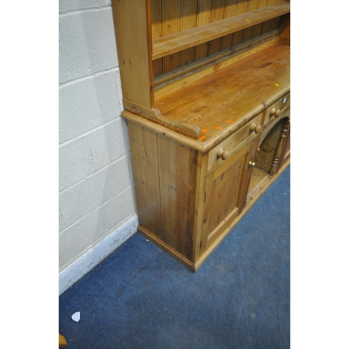 1263 - AN EARLY 20TH CENTURY PINE DRESSER, the three tier plate rack atop a base with three drawers, two cu... 