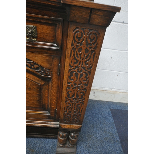 1290 - AN EARLY 20TH CENTURY OAK SIDEBOARD, with a raised back, blind fretwork detail, two drawers, above d... 