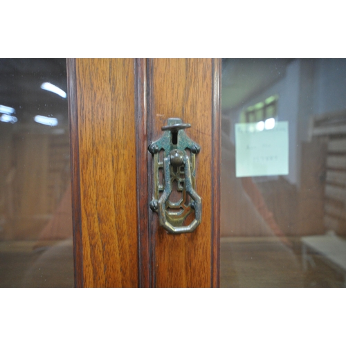 1294 - AN EARLY 20TH CENTURY WALNUT BOOKCASE, the double glazed doors enclosing two adjustable shelves, rai... 