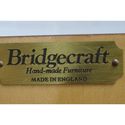 1307 - BRIDGECRAFT, A MAHOGANY COCKTAIL CABINET, with scrolled crest and apron, the top doors enclosing a m... 