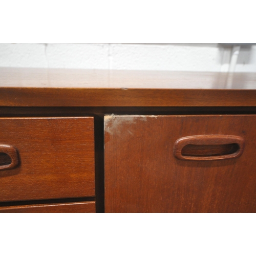 1311 - A MID CENTURY TEAK SIDEBOARD, fitted with two cupboard doors, flanking three graduated drawers, the ... 