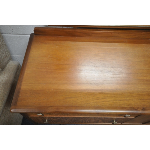 1312 - A MID CENTURY TEAK DRESSING TABLE, with a rectangular mirror, and four drawers, raised on square tap... 