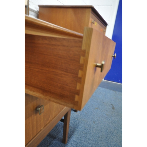 1312 - A MID CENTURY TEAK DRESSING TABLE, with a rectangular mirror, and four drawers, raised on square tap... 