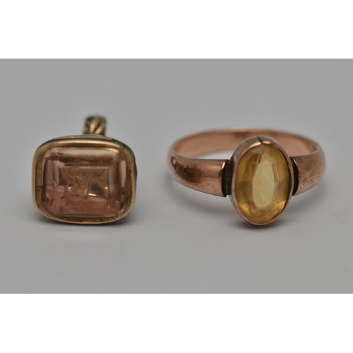 15 - TWO EARLY 20TH CENTURY JEWELLERY ITEMS, the first an oval cut citrine, collet set in rose metal, unm... 