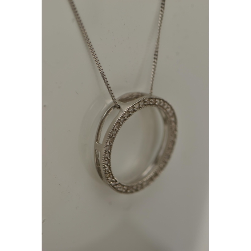 17 - A 9CT GOLD DIAMOND PENDANT, a circular form white gold pendant, grain set with round brilliant cut d... 