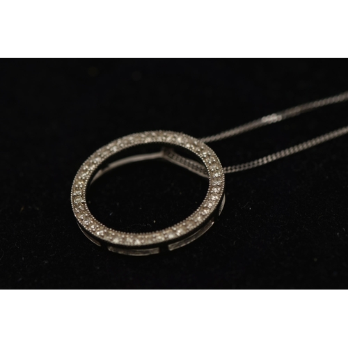 17 - A 9CT GOLD DIAMOND PENDANT, a circular form white gold pendant, grain set with round brilliant cut d... 