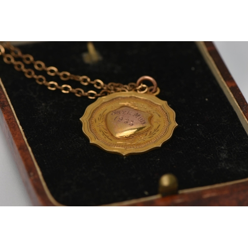 42 - A 9CT GOLD PENDANT WITH A CHAIN, a 9ct gold circular fob pendant with engraved shield cartouche read... 