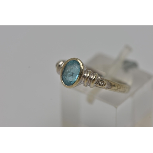 5 - A WHITE METAL GEM SET RING, an oval cut topaz, bezel set, flanked with four round brilliant cut diam... 