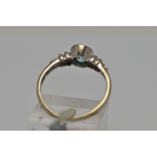 5 - A WHITE METAL GEM SET RING, an oval cut topaz, bezel set, flanked with four round brilliant cut diam... 