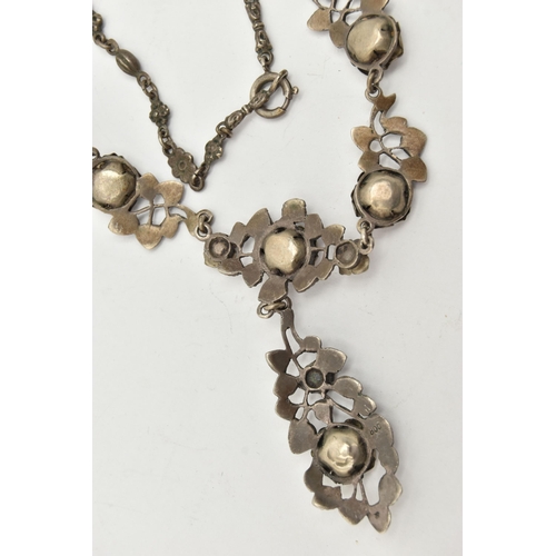 69 - A WHITE METAL NECKLACE, of a floral design set with worn coral cabochons (one is missing), fancy lin... 