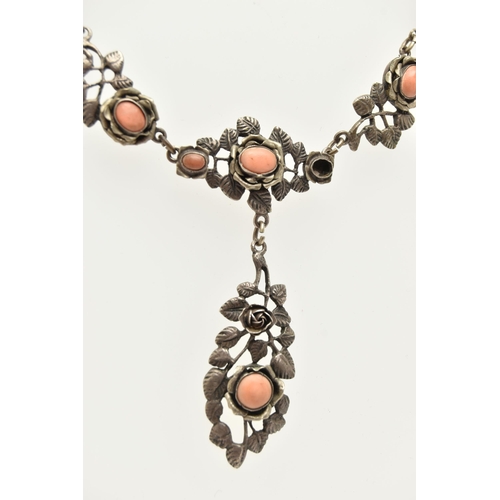 69 - A WHITE METAL NECKLACE, of a floral design set with worn coral cabochons (one is missing), fancy lin... 