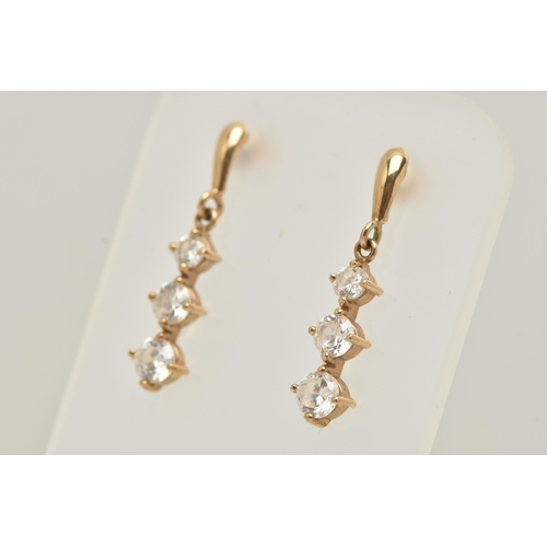 148 - A PAIR OF YELLOW METAL CUBIC ZIRCONIA DROP EARRINGS, designed as a row of three graduated colourless... 