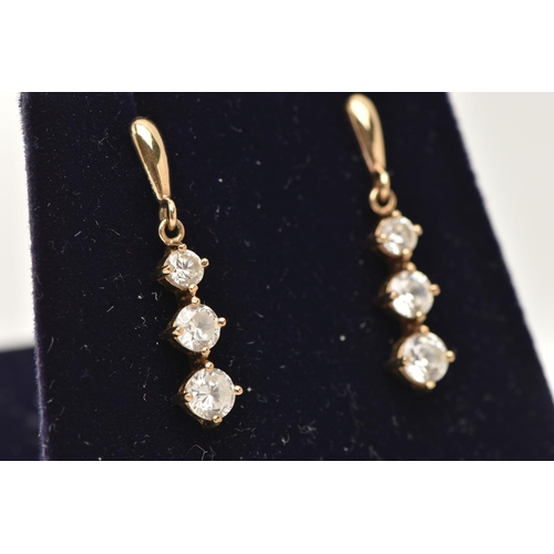 148 - A PAIR OF YELLOW METAL CUBIC ZIRCONIA DROP EARRINGS, designed as a row of three graduated colourless... 