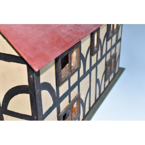 386 - A SCRATCHBUILT SMALL SCALE WOODEN DOLLS HOUSE, c.1950s, modelled as a half-timbered house, front ope... 