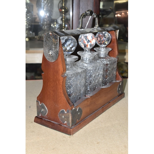 396 - A TWENTIETH CENTURY TANTALUS, containing three cut glass square decanters, plated handle and mounts,... 