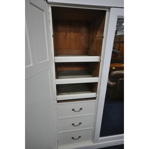 1196 - A WHITE PAINTED PINE TRIPLE DOOR WARDROBE, the middle door with a mirror, the left door enclosing a ... 